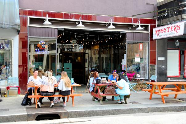 Groups of people seated at picnic tables eating