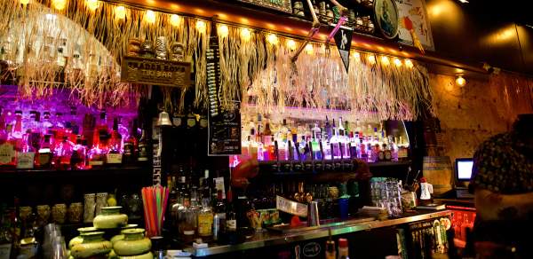 Bar decorated with hula skirts, flags and a skeleton.