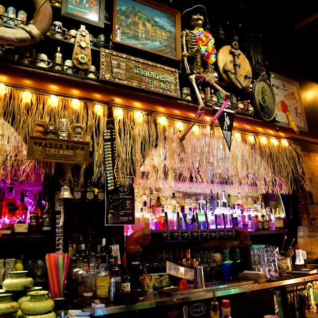 Bar decorated with hula skirts, flags and a skeleton.