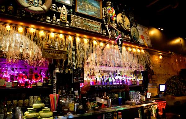 Bar decorated with hula skirts, flags and a skeleton.