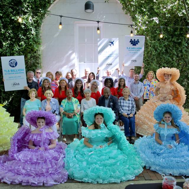 group of people standing among five Azalea Trail Maids in Antebellum dresses