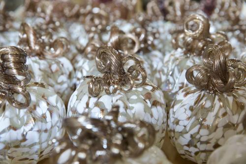 Image shows close up of tan, beige and white colored glass-blown pumpkin