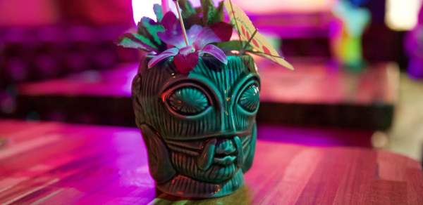 Tiki themed cocktail shot in colorful light.