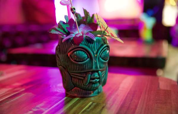 Tiki themed cocktail shot in colorful light.