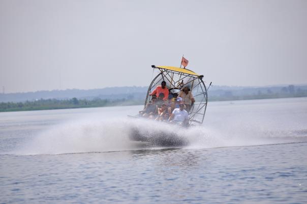 people riding in airboat in the bay