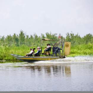 People riding in an airboat in the Mobile Bay
