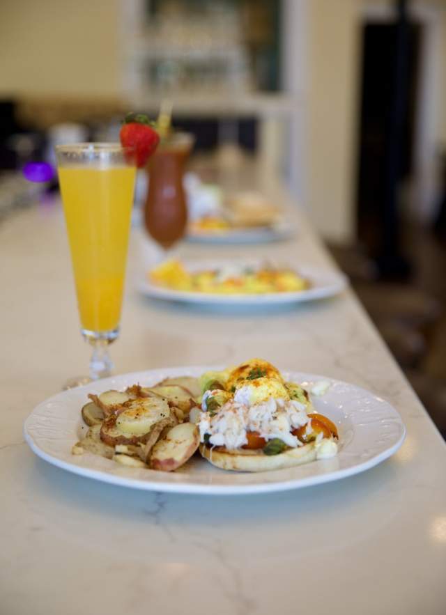 Breakfast plate on a bar with a mimosa cocktail