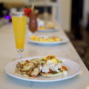Breakfast plate on a bar with a mimosa cocktail