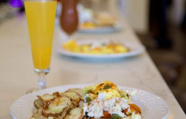 Breakfast plate on a bar with a mimosa cocktail