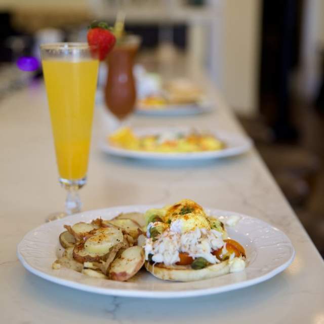 Breakfast plate on a bar with a mimosa cocktail