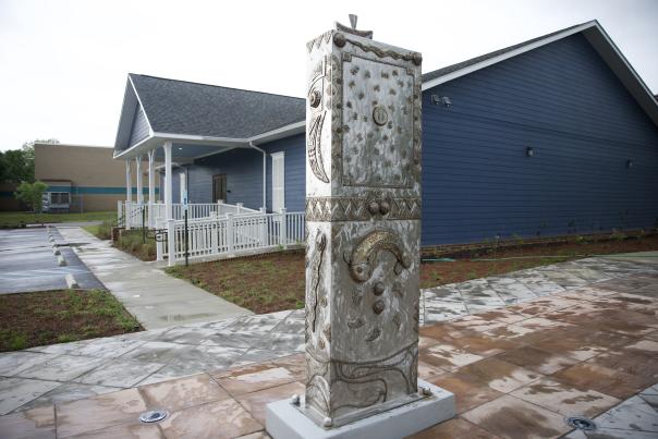 house behind a rectangular, steel sculpture