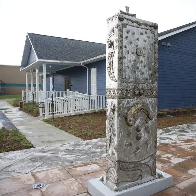 house behind a rectangular, steel sculpture