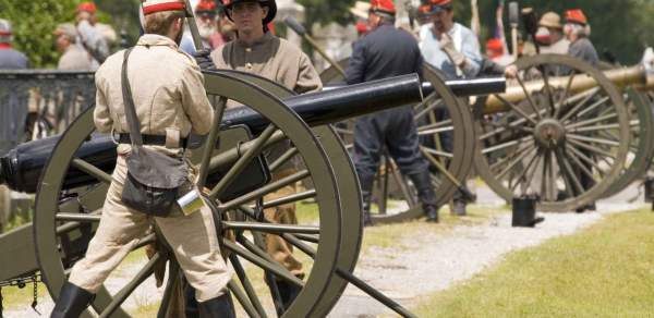 a soldier operating a cannon at a battle reenactment