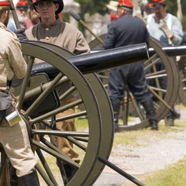 a soldier operating a cannon at a battle reenactment