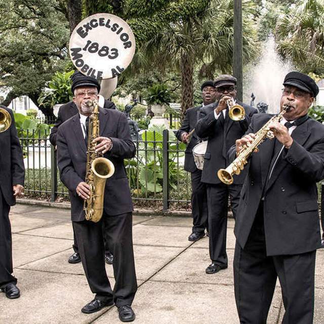 brass band playing in the park with people dancing