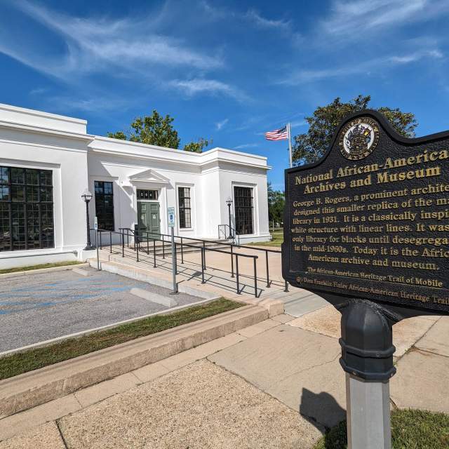 white building with an iron sign: National African American Archives and Museum