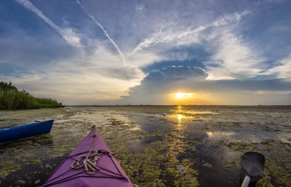 View of sunset over the water from a kayak