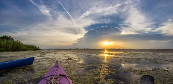 View of sunset over the water from a kayak