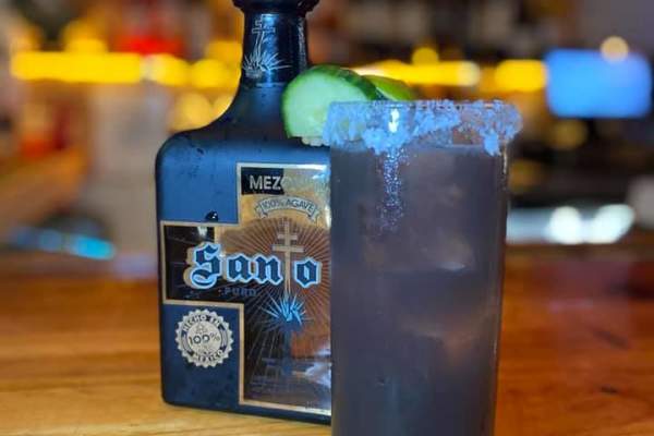 Bottle of liquor, tall glass with mixed drink