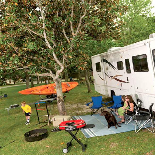 people relaxing in front of a camper or RV