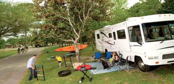 people relaxing in front of a camper or RV
