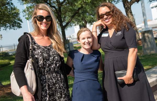 three smiling women on a sunny day