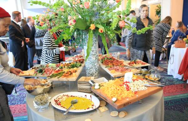 Table of catered food with people around it