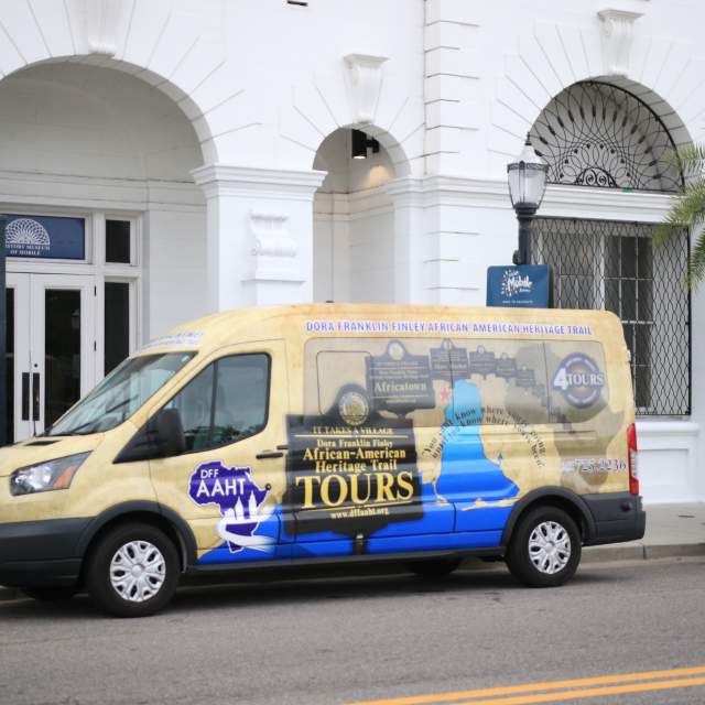 colorful passenger van parked in front of white building