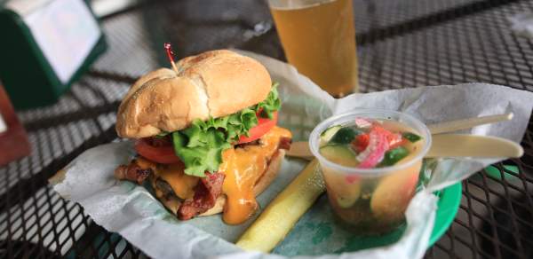 Bacon Cheeseburger, pickle spear, cup of tomato and cucumber salad