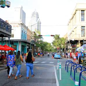 group of people walking down Dauphin Street