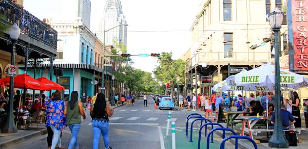 group of people walking down Dauphin Street