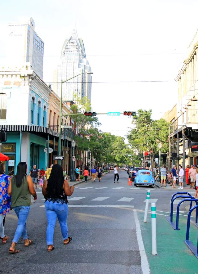 group of people walking down Dauphin Street