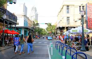 group of people walking down Dauphin Street