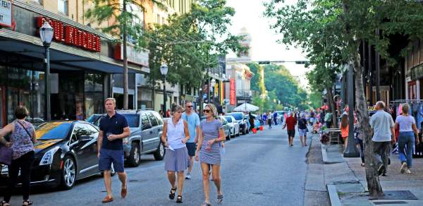 group of people walking downtown Dauphin Street