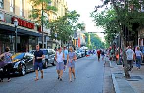 group of people walking downtown Dauphin Street