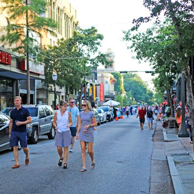 group of people walking downtown Dauphin Street