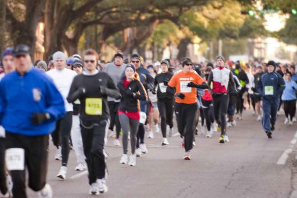 group of people running down the street in a race