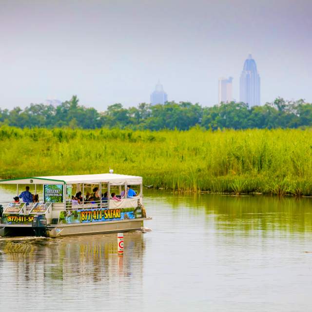 Safari tours boat in the Mobile Bay with the city in the background