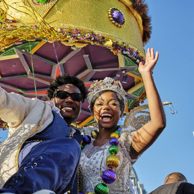 Mardi Gras king and queen waving