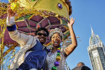 Mardi Gras king and queen waving