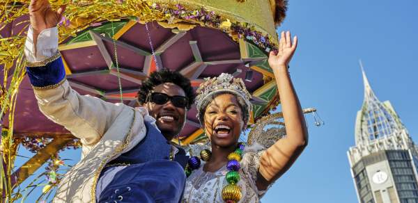 Mardi Gras king and queen waving