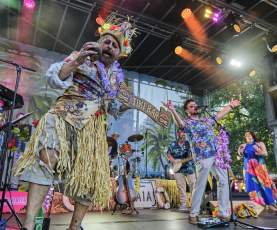 A band dressed like pirates plays music on a stage