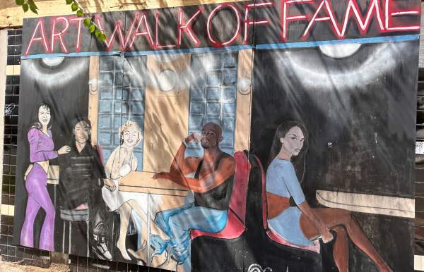 Art Walk of Fame mural with people seated at outdoor tables