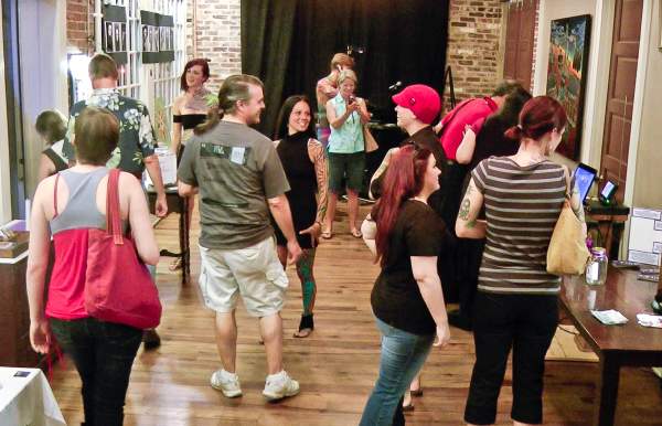 a group of people browsing art at an art gallery in mobile