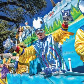 Man in Mardi Gras costume riding a Mardi Gras float