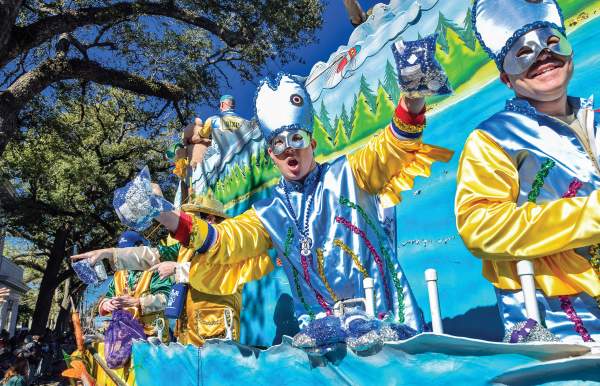 Man in Mardi Gras costume riding a Mardi Gras float