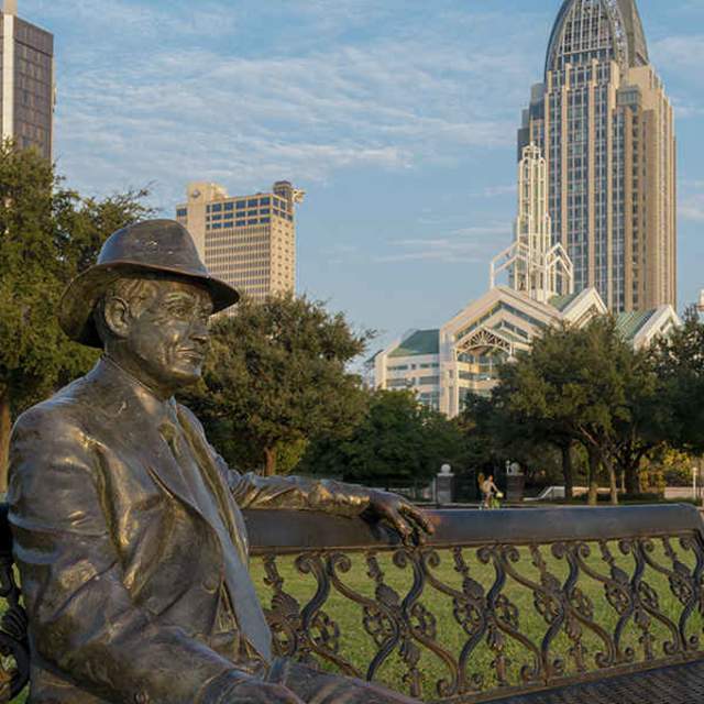 iron statue of a man sitting on a bench