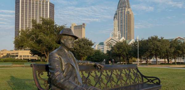 iron statue of a man sitting on a bench