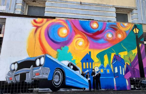 Blue car in front of colorful background