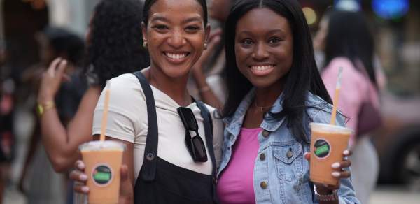 Two women posing and holding cups